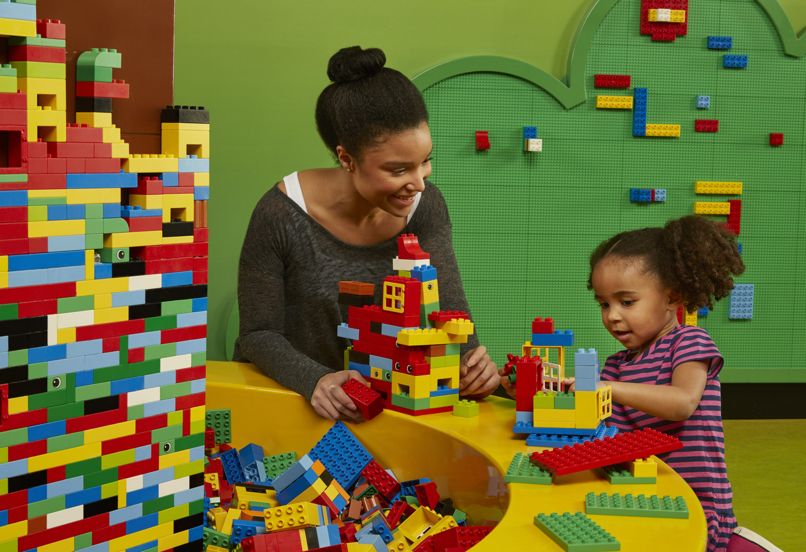 A mother and child building colorful LEGO structures at LEGOLAND Discovery Center in Schaumburg, Illinois. This popular indoor play place offers hands-on creativity, interactive exhibits, and family fun.