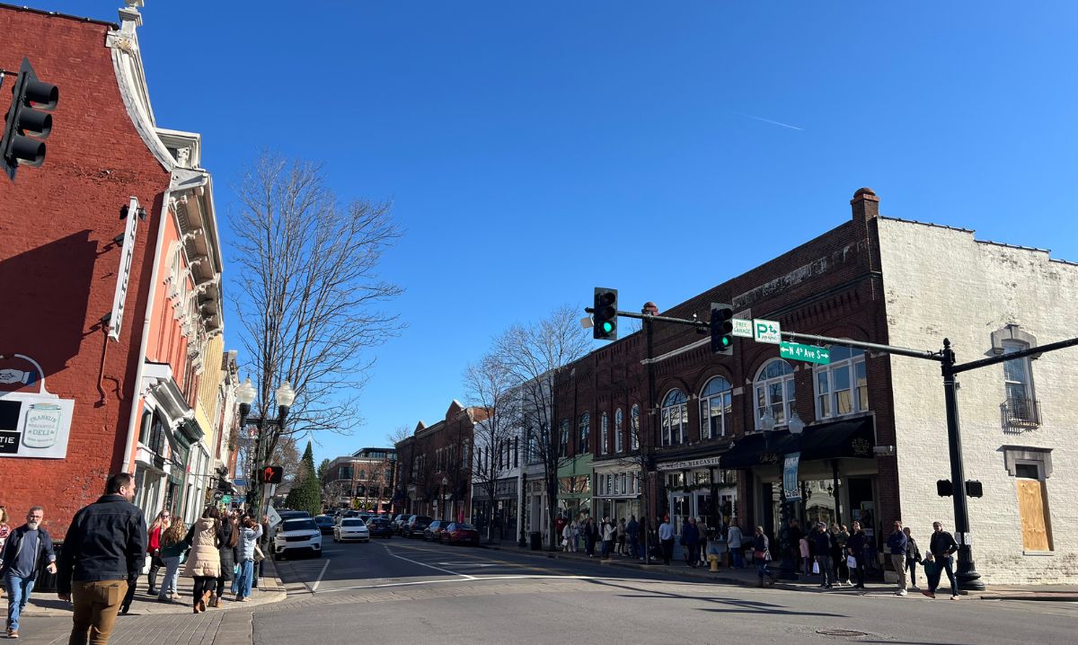 A bustling Main Street in downtown Franklin, Tennessee, featuring historic brick buildings, local shops and pedestrians enjoying the charming small-town atmosphere.